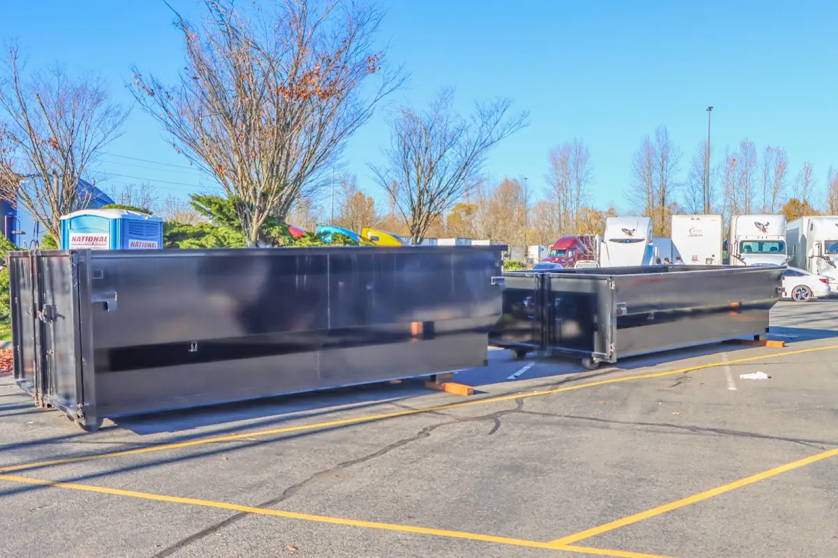 Professional dumpster rental service with roll-off container on residential driveway in Grand Ledge